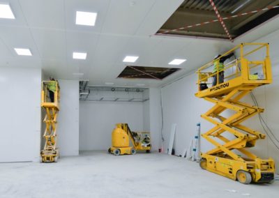 engins de chantier orange dans une salle blanche conception par Rosin Entreprise