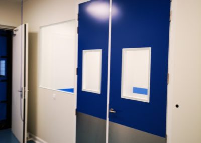 porte bleue avec un panneau en métal sur le bas par Rosin Entreprise